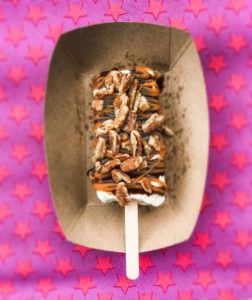 Delicious popsicle with nuts and pink background