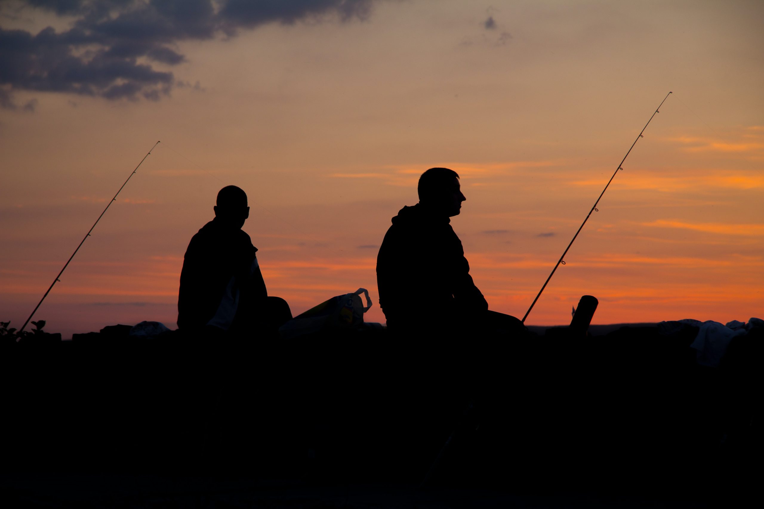 Two fishermen in silhouette at dusk