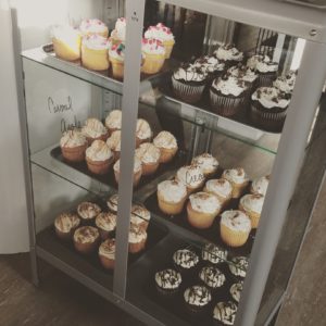 a 3-tiered display case filled with cupcakes.
