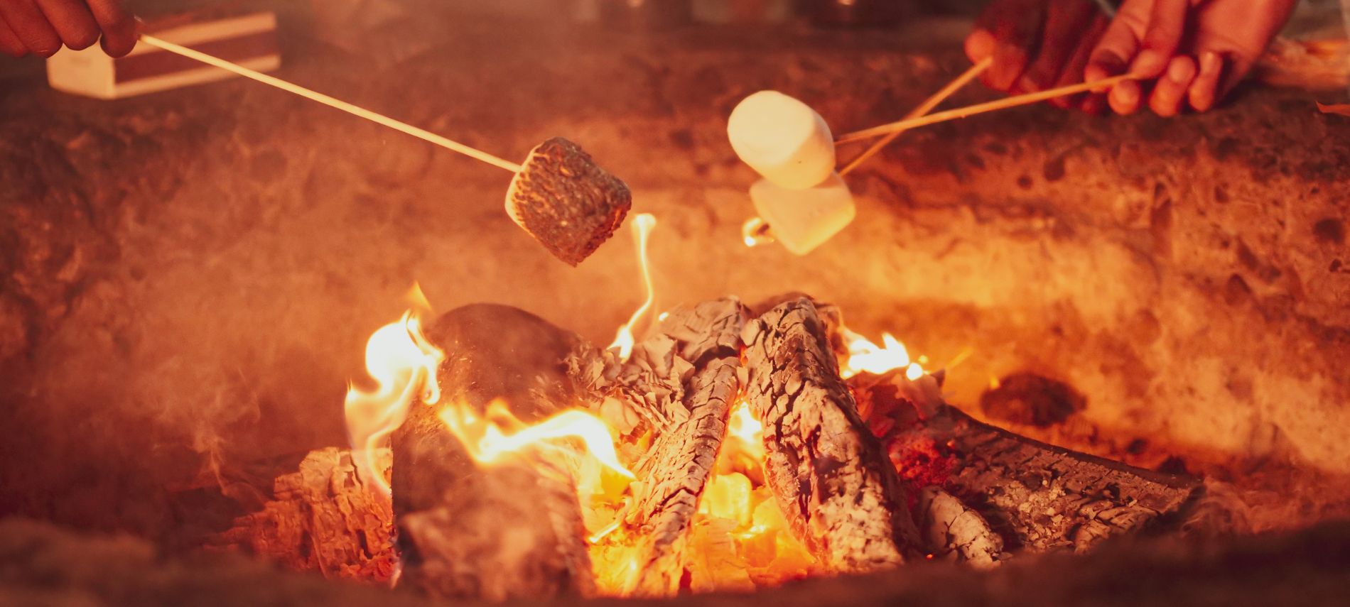 People roasting marshmallows over a campfire.