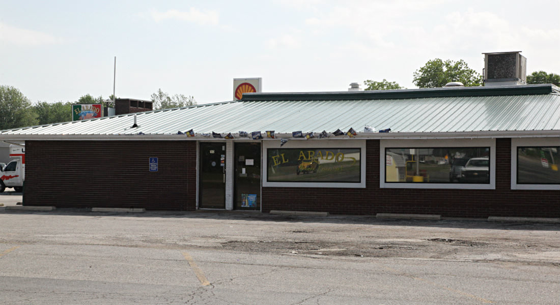 Brown Brick building with silver metal roof for with sign for El Arado Mexican Restaurant, Shell Sign and U-Haul beside.